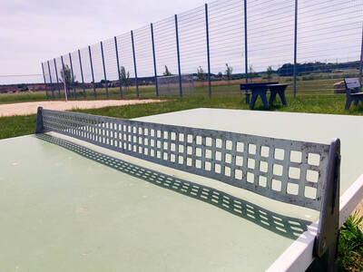 Neben dem Fußballplatz mit Ballfangzaun befindet sich auf dem Freizeitgelände Untermembach auch eine Tischtennisplatte mit Metallnetz.